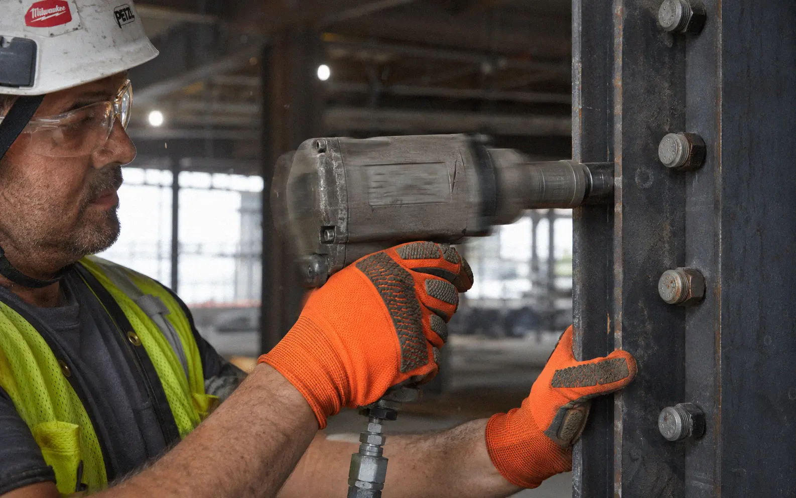 Worker wearing anti-vibration gloves while operating a pneumatic tool